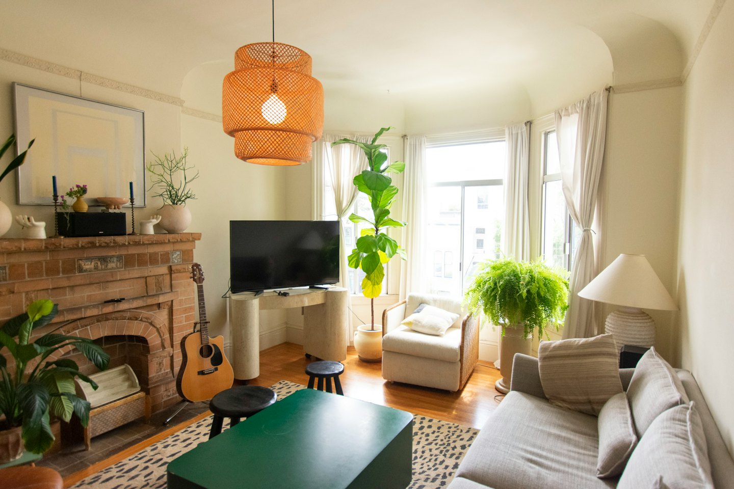 Gitarre lehnt an einem Kamin aus Ziegelsteinen im Wohnzimmer.